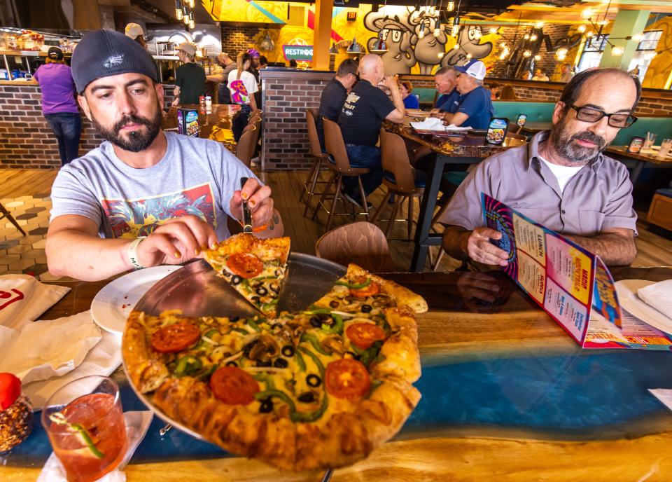 Mitch Miller grabs another slice of his veg-out pizza on Dec. 4 at Mellow Mushroom. That was Opening Day for the long-awaited pizza restaurant in downtown Ocala.