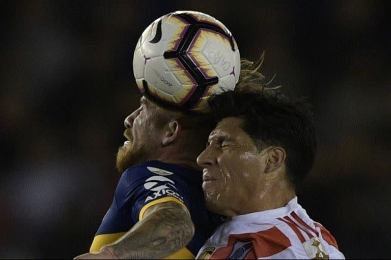 Alexis MacAllister y Enzo Pérez chocan sus cabezas al disputar la pelota en el partido de ida de las semifinales de la Copa Libertadores 2019