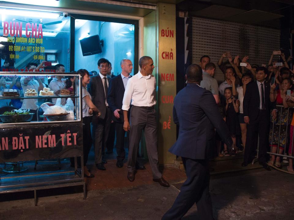 US President Barack Obama (C) departs after eating dinner at Bun cha Huong Lien with CNN's Anthony Bourdain in Hanoi late on May 23, 2016