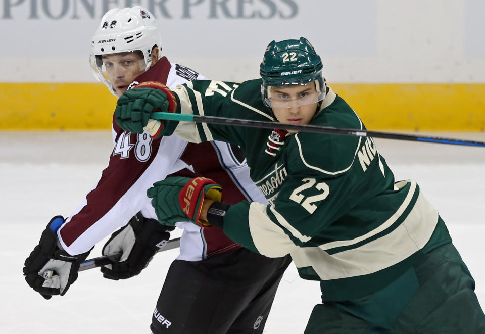 Minnesota Wild&#39;s Nino Niederreiter, right, of Switzerland, eyes the puck as he tries to keep Colorado Avalanche&#39; s Daniel Briere at bay in the first period of an NHL hockey game, Thursday, Oct. 9, 2014, in St. Paul, Minn. (AP Photo/Jim Mone)