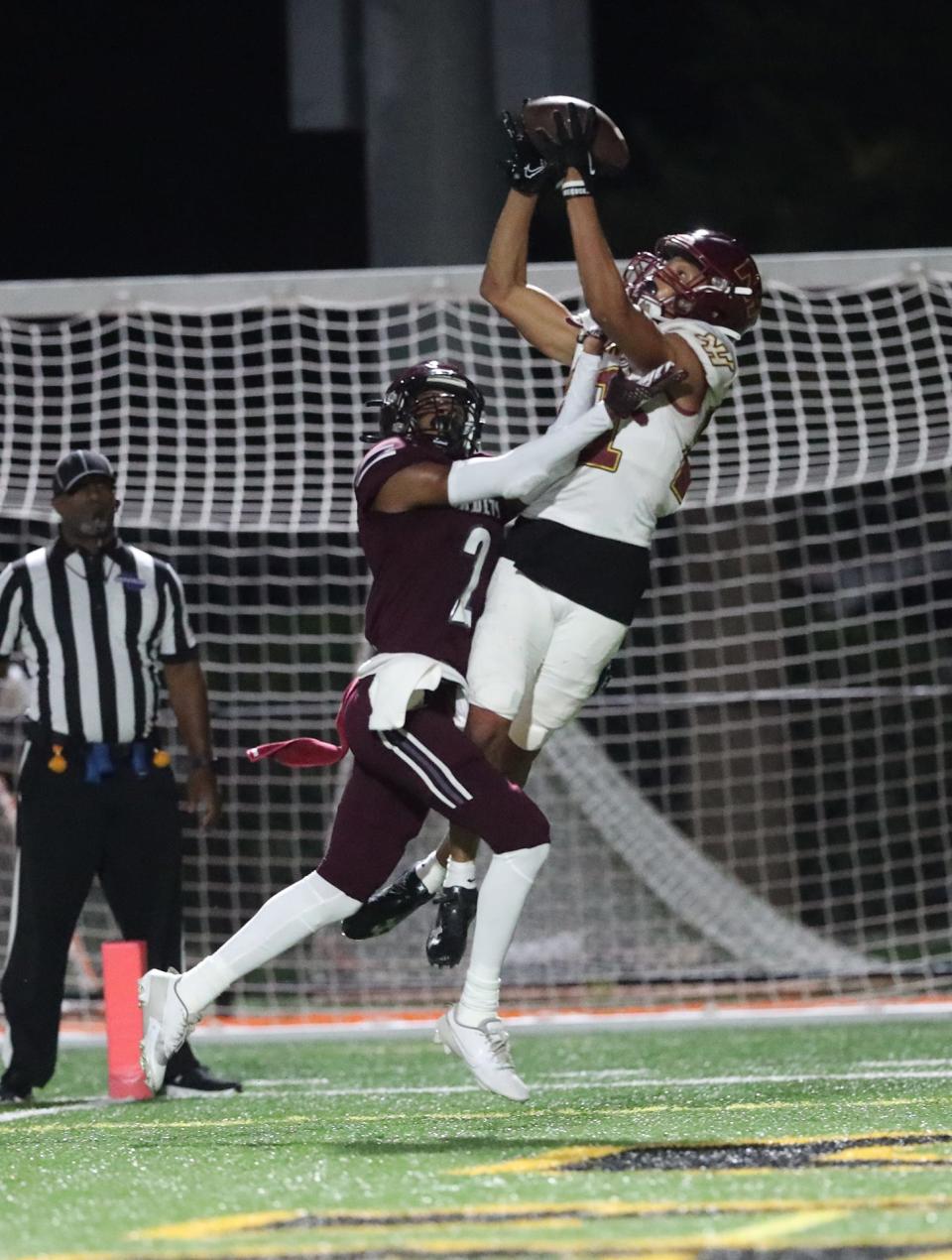 New Hampstead's Kamari Maxwell elevates to make a touchdown catch over Benedictine's Micah Williams during a 2023 game at Memorial Stadium.