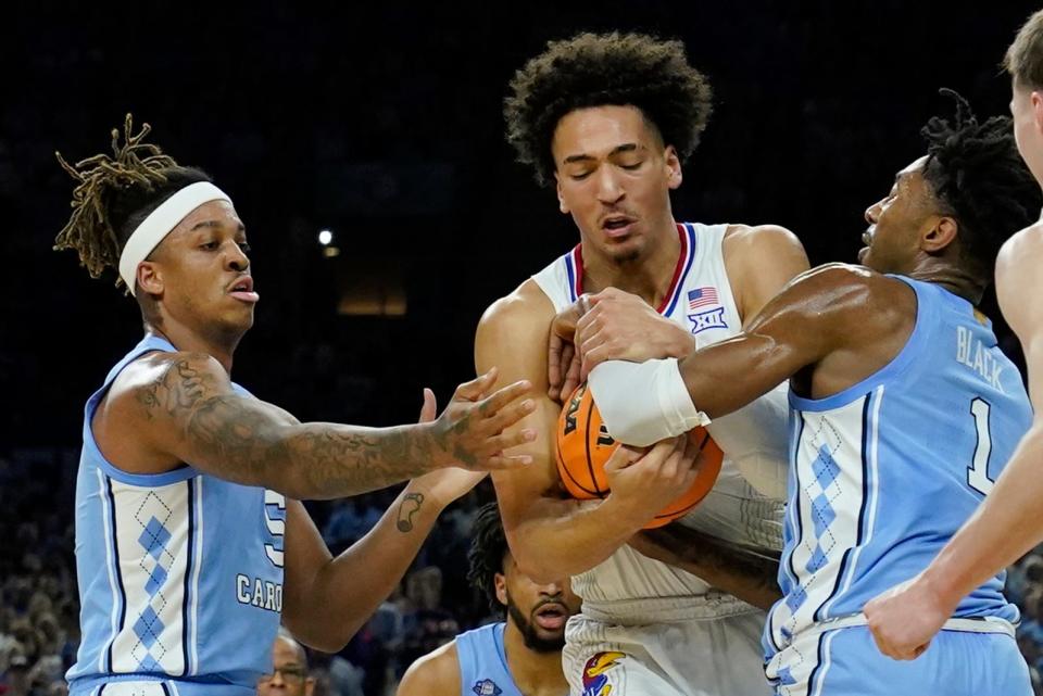 Kansas forward Jalen Wilson, center, battles for the ball with North Carolina forward Armando Bacot, left, and guard Leaky Black during the first half of the national championship game of the NCAA tournament on April 4, 2022, in New Orleans.