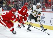 Vegas Golden Knights left wing William Carrier (28) passes the puck against Detroit Red Wings defenseman Filip Hronek, left, and center Austin Czarnik (21) during the first period of an NHL hockey game Saturday, Dec. 3, 2022, in Detroit. (AP Photo/Duane Burleson)