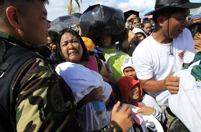 A woman and her child plead from the frantic crowd to be prioritized on an evacuation flight in Tacloban, central Philippines, Thursday, Nov. 14, 2013. Typhoon Haiyan, one of the most powerful storms on record, hit the country's eastern seaboard on Friday, destroying tens of thousands of buildings and displacing hundreds of thousands of people. (AP Photo/Wally Santana)