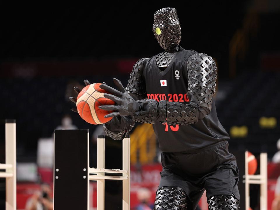 A robot takes shots on the basketball court during halftime of USA-France at Tokyo 2020.