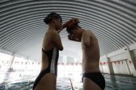 Yang Ping (L), 22, from the Yunzhinan Swimming Club for the handicapped, puts on swimming goggle for her teammate Xu Qing, 20, during a daily training session at a swimming centre in Kunming, southwest China's Yunnan province, July 30, 2011.