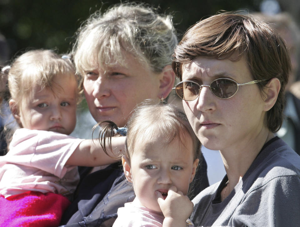 FILE - Yelena, right, wife of Vyacheslav Milashevsky, commander of the Russian AS-28 mini-submarine, and unidentified relative hold children as they wait outside a hospital in Russia's far eastern city of Petropavlovsk-Kamchatsky, Monday, Aug. 8, 2005. Rescuers cut the Russian mini-submarine free of tangled deep-sea cables, saving its seven crew with British help, after a three-day ordeal deep in the Pacific with dwindling oxygen. (AP Photo/Viktor Korotayev, Pool)