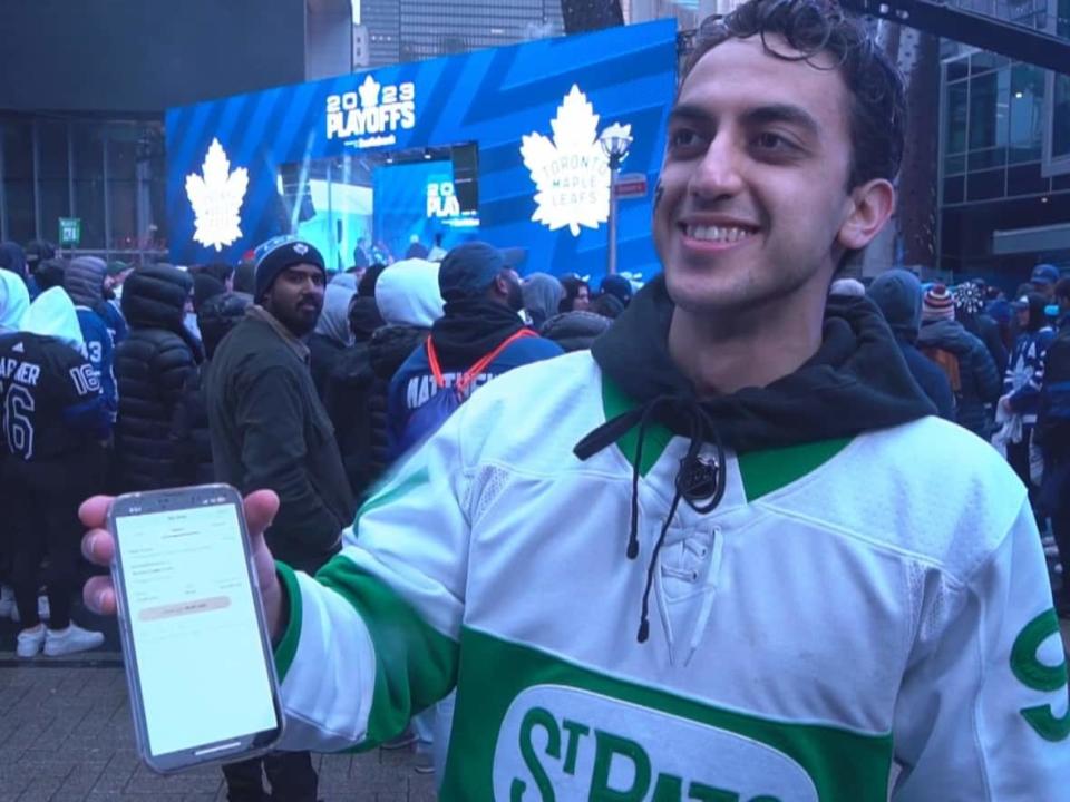 Wayne Madd displays his most recent bet, made from his phone while watching a Toronto Maple Leafs game with thousands of others of fans outside Scotiabank Arena.  (Michael Drapak/CBC - image credit)