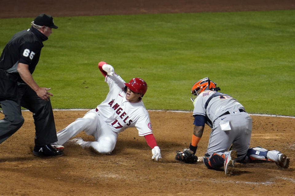 Los Angeles Angels' Shohei Ohtani (17) reacts after scoring on a fielder's choice past Houston Astros catcher Martin Maldonado on a ground ball by Jared Walsh during the eighth inning of a baseball game, Monday, April 5, 2021, in Anaheim, Calif. (AP Photo/Marcio Jose Sanchez)