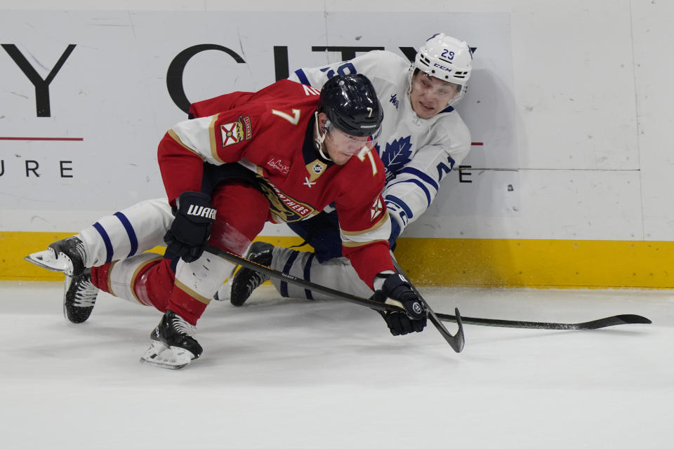 Florida Panthers defenseman Dmitry Kulikov (7) and Toronto Maple Leafs right wing Pontus Holmberg (29) battle for the puck during the first period of an NHL hockey game, Tuesday, April 16, 2024, in Sunrise, Fla. (AP Photo/Wilfredo Lee)