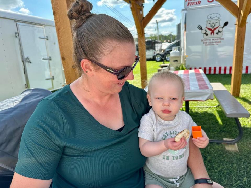 Megan Norris of Bellefonte and her 15-month-old son Colt share a soft pretzel at Grange Fair on Saturday, Aug. 19, 2023.