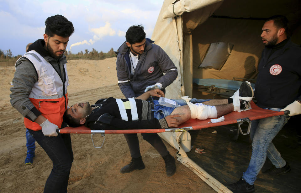 Medics move a wounded protester to the hospital by an Ambulance after being shot during a protest near the fence of the Gaza Strip border with Israel, near Beit Lahiya, northern Gaza Strip, Tuesday, Feb. 19, 2019. (AP Photo/Adel Hana)