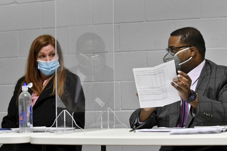 FILE - Wayne County Board of Canvassers Republican chairperson Monica Palmer, left, and Democrat vice chair Jonathan Kinloch discuss a motion to certify the election during a board meeting in Detroit on Nov. 17, 2020. In Michigan, the county canvassing board is comprised of two Republicans and two Democrats. In Wayne County, which includes Detroit, Republican board members initially voted against certifying the 2020 election but later reversed course. (Robin Buckson/Detroit News via AP, File)