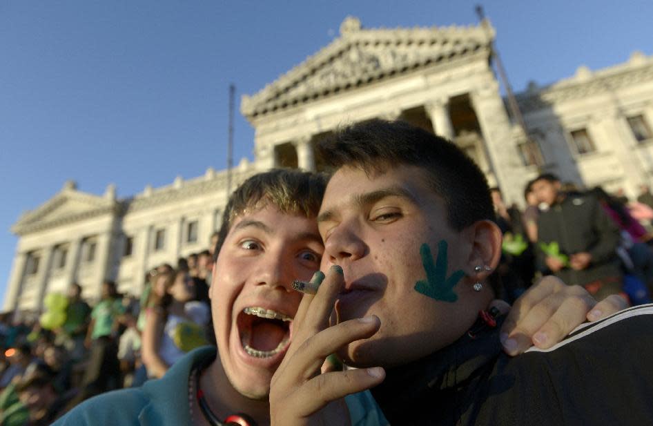 FILE -This Dec. 10, 2013 file photo shows, activists smoking marijuana, as they pose for photos in front of the Congress in Montevideo, Uruguay. Uruguay's Senate approved the world's first national marketplace for legal marijuana. From the Americas to Europe to North Africa and beyond, the marijuana legalization movement has unprecedented traction, a nod to successful efforts in Colorado, Washington and the small South American nation of Uruguay, which became the first country to approve nationwide pot legalization. (AP Photo/Matilde Campodonico, File)