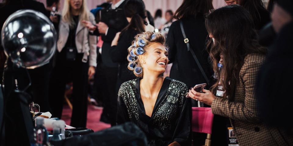 <p>Romee Strijd laughs while getting her hair done and giving interviews backstage. </p>