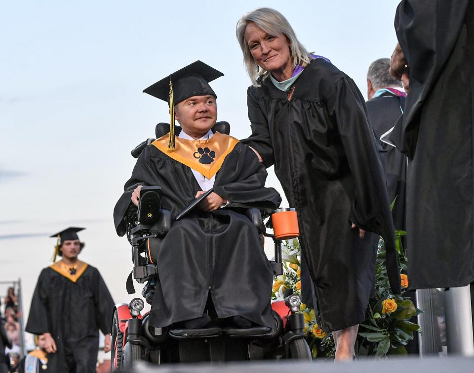 Lee McMahan gets his diploma near Superintendent Kathy HIpp, Anderson School District Three, during the Crescent High School commencement at the school stadium in Iva, S.C. Monday, May 20, 2024.