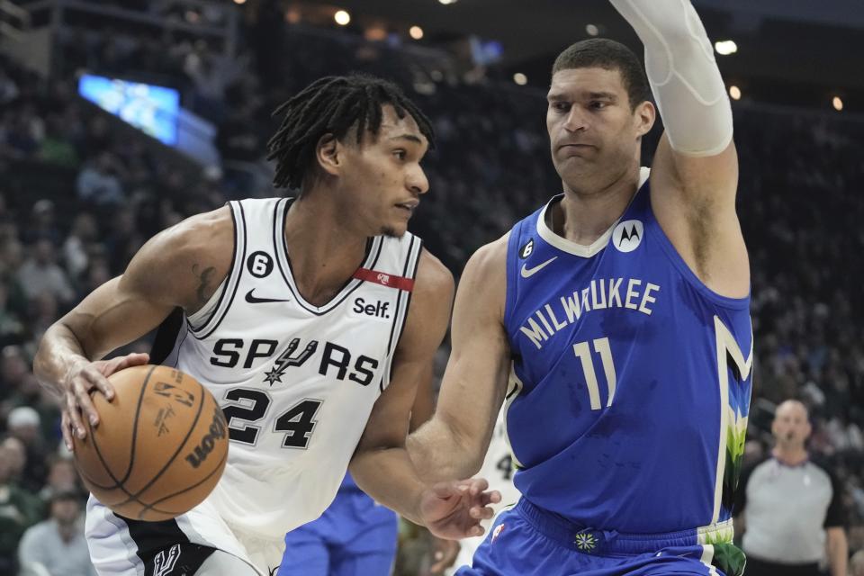 San Antonio Spurs' Khem Birch tries to get past Milwaukee Bucks' Brook Lopez during the first half of an NBA basketball game Wednesday, March 22, 2023, in Milwaukee. (AP Photo/Morry Gash)