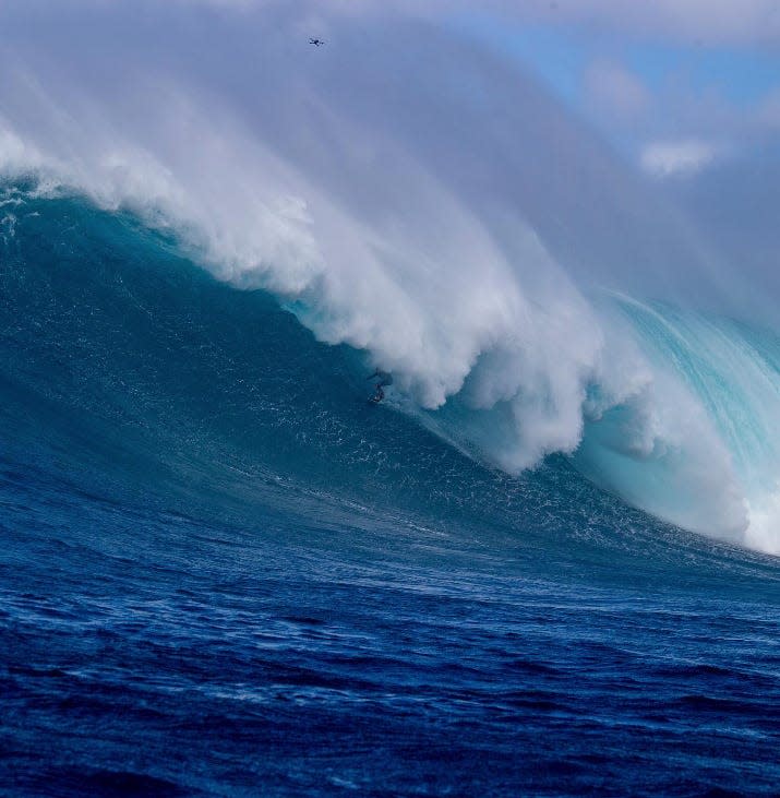 screenshot of a surfer riding a massive wave