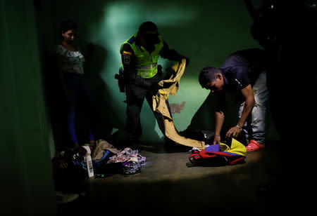 Colombian police officers check belongings in a house where undocumented Venezuelans migrants live during a raid in Villa del Rosario, Colombia August 24, 2018. REUTERS/Carlos Garcia Rawlins