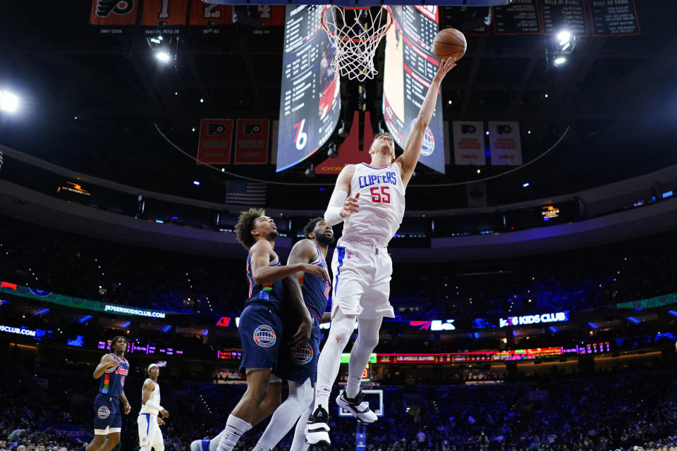 Los Angeles Clippers' Isaiah Hartenstein, right, goes up for a shot past Philadelphia 76ers' Joel Embiid, center, and Charlie Brown Jr. during the first half of an NBA basketball game, Friday, Jan. 21, 2022, in Philadelphia. (AP Photo/Matt Slocum)