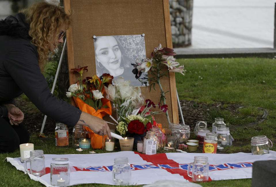 A woman lights candles during a candlelight vigil for murdered British tourist Grace Millane at Cathedral Square in Christchurch, New Zealand, Wednesday, Dec. 12, 2018. (AP Photo/Mark Baker)