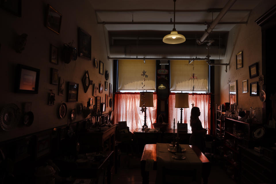 Cora Anderson, 9, from Macon, Ill., is silhouetted as she walks through the Galesburg Antiques Mall, Wednesday, June 16, 2021, in Galesburg, Il. (AP Photo/Shafkat Anowar)