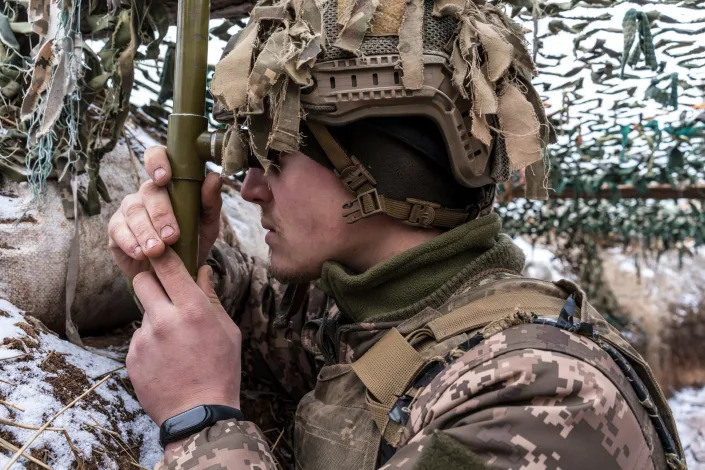 A Ukrainian soldier uses a hand-held periscope to view the positions of Russian-backed troops in a trench near the front line on Jan. 17, 2022 in the village of New York, formerly known as Novhorodske, Ukraine.