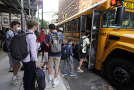 FILE — In this Sept. 13, 2021, file photo, students board a school bus on New York's Upper West Side. Even as most students return to learning in the classroom this school year, disruptions to in-person learning, from missing one day because of a late school bus to an entire two weeks at home due to quarantine, remain inevitable as families and educators navigate the ongoing pandemic. (AP Photo/Richard Drew, File)