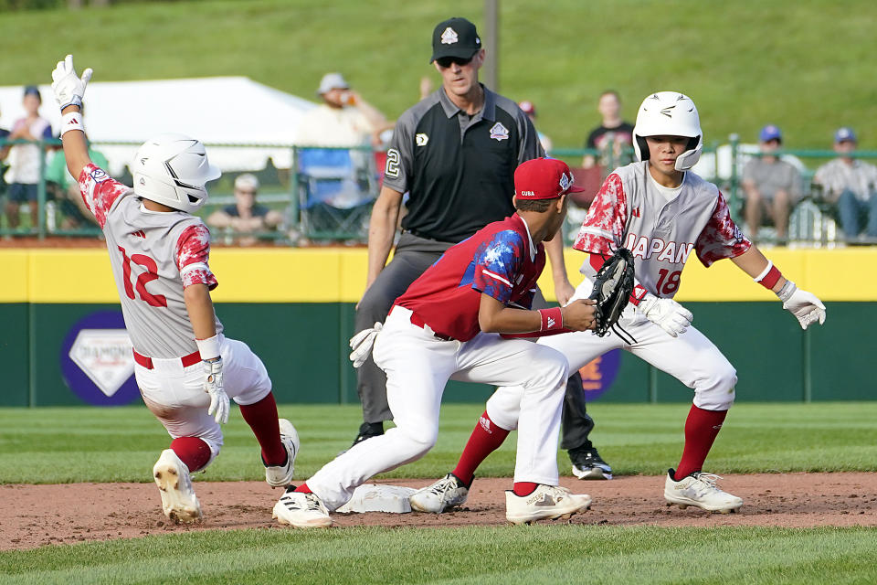Japan's Taiga Tsutsui (12) slides back into second base as Cuba's Liusban Sanchez (12) looks at Japan's Yohei Yamaguchi (18), also at second, during the fifth inning of a baseball game at the Little League World Series tournament in South Williamsport, Pa., Wednesday, Aug. 16, 2023. (AP Photo/Tom E. Puskar)