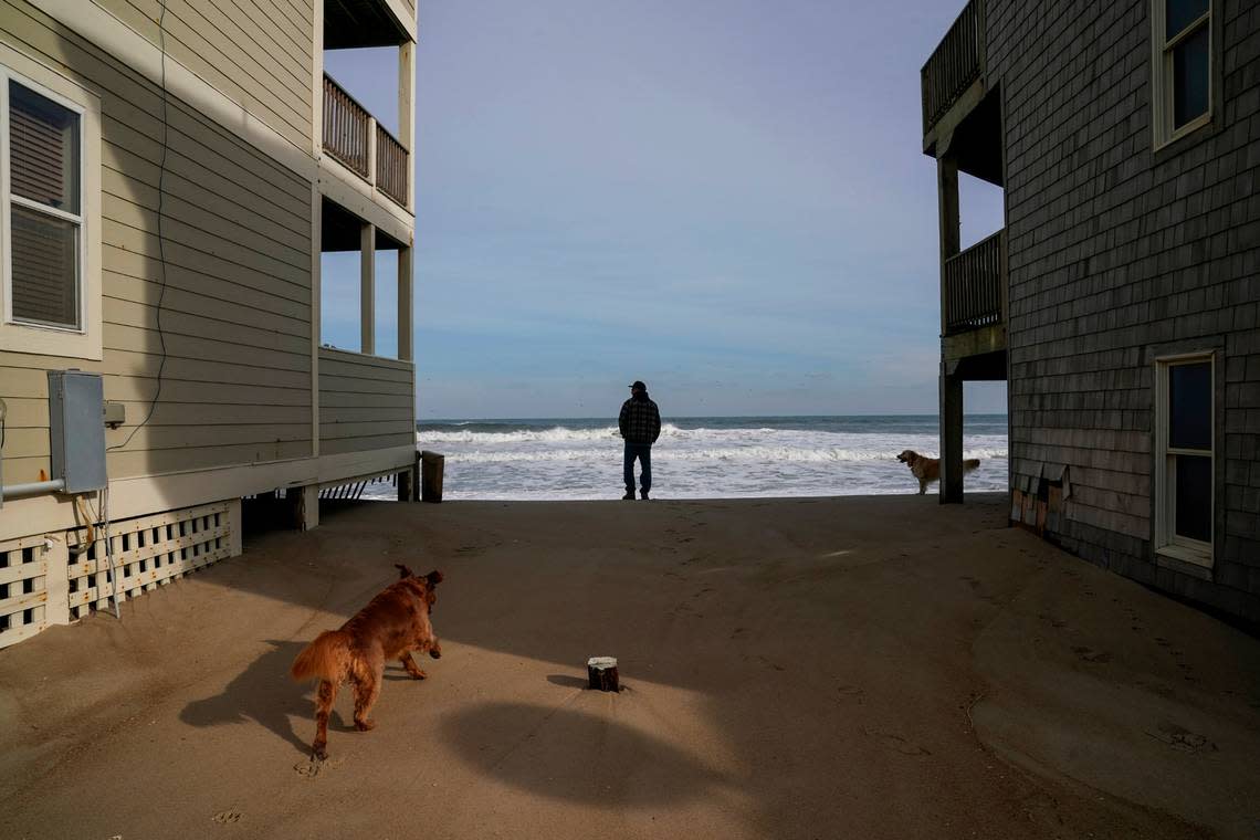 Tom Urban, from Golden, Colo., watches the rising tide in the Outer Banks town of Rodanthe, N.C.