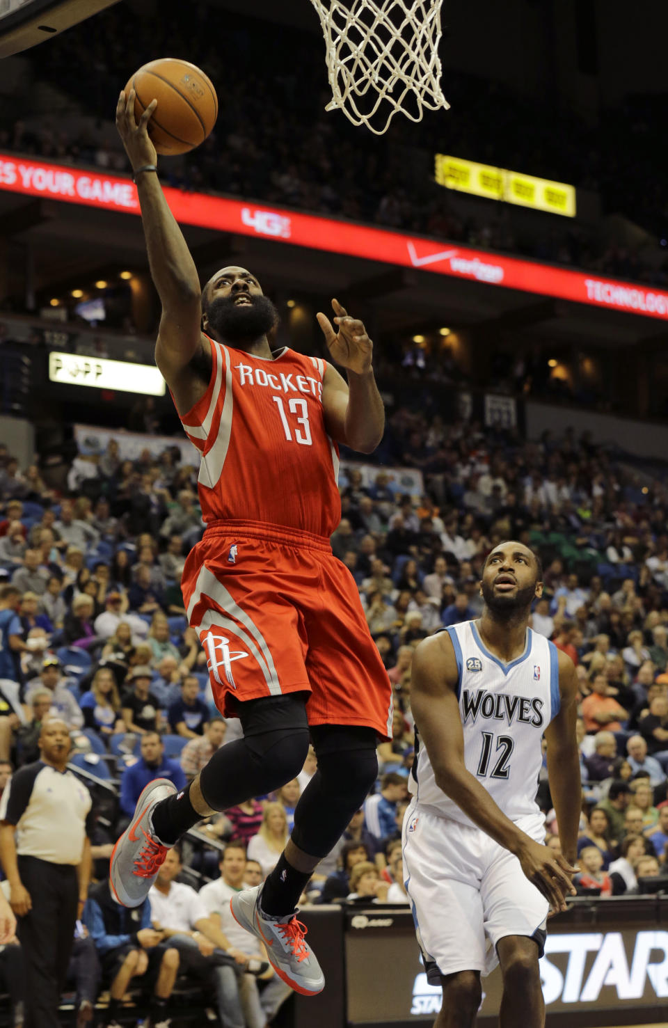 Houston Rockets guard James Harden (13) goes up for a shot in front of Minnesota Timberwolves forward Luc Richard Mbah a Moute (12) during the second quarter of an NBA basketball game in Minneapolis, Friday, April 11, 2014. (AP Photo/Ann Heisenfelt)