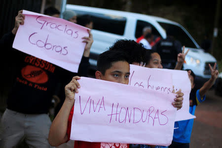 Supporters hold placards during a strike by members of the Honduran police to demand higher wages and rest after working extra hours due to protests caused by the delay in vote counting in the general election, at their headquarters in Tegucigalpa, Honduras, December 4, 2017. REUTERS/Jorge Cabrera
