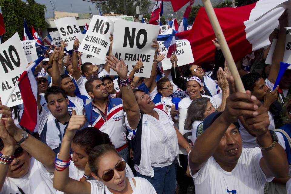 Supporters of Norman Quijano, Nationalist Republican Alliance presidential candidate, many holding posters that read in Spanish; "No to electoral fraud," demand a vote recount of Sunday's runoff election during a protest, in San Salvador, El Salvador, Tuesday, March 11, 2014. El Salvador's too-close-to-call election has raised competing claims of victory from the two candidates; Salvador Sanchez Ceren of the Farabundo Marti National Liberation Front and Quijano. (AP Photo/Esteban Felix)