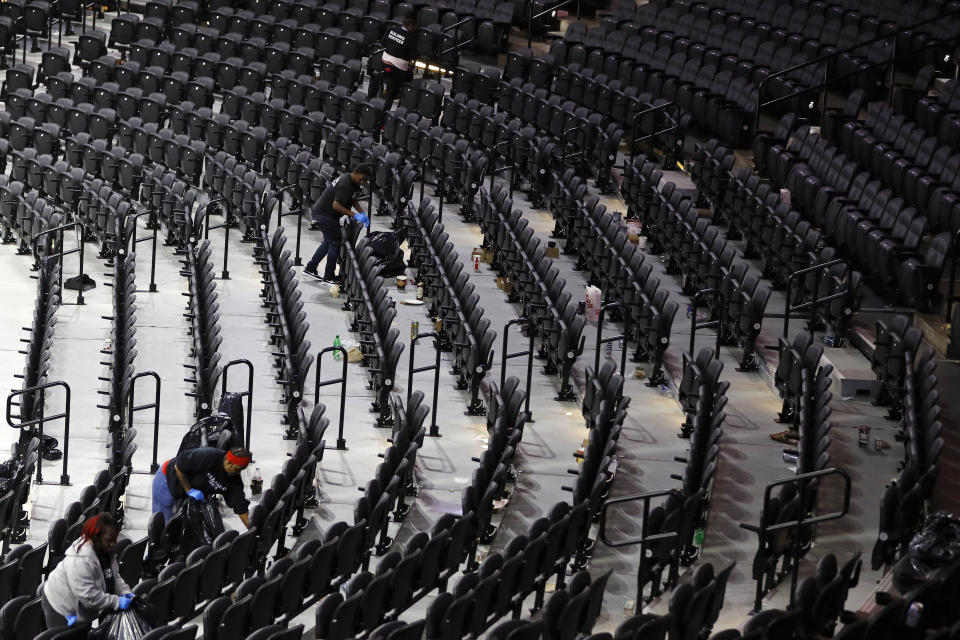 Workers clean the Wells Fargo Center after an NBA basketball game between the Philadelphia 76ers and the Detroit Pistons, Wednesday, March 11, 2020, in Philadelphia. (AP Photo/Matt Slocum)