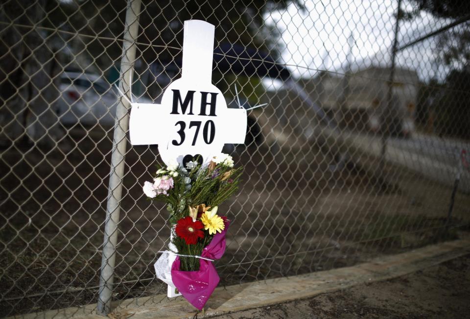 A memorial cross and bouquet in honour of Malaysia Airlines flight MH370 is pictured outside the front gate of the Royal Australian Air Force base Pearce, near Perth