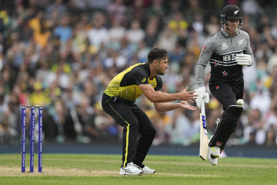 Australia's Marcus Stoinis, left, fields the ball as New Zealand's Finn Allen runs to make his ground during the T20 World Cup cricket match between Australia and New Zealand in Sydney, Australia, Saturday, Oct. 22, 2022. (AP Photo/Rick Rycroft)