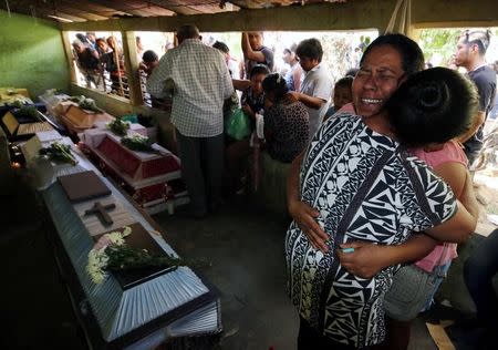 A relative cries near coffins with the bodies of the victims, after a military helicopter carrying Mexico's interior minister and the governor of the southern state of Oaxaca, crashed on top of two vans in an open field while trying to land, in Santiago Jamiltepec, Mexico February 17, 2018. REUTERS/Jorge Luis Plata