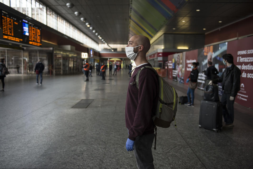 People with protective masks wait for a train in Turin, Italy, on Monday.