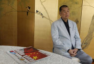 Hong Kong media tycoon Jimmy Lai pauses next to a copy of Apple Daily's July 1, 2020, edition during an interview Hong Kong Wednesday, July 1, 2020. A newspaper that has advocated for greater democracy in Hong Kong came under further pressure Thursday, June 17, 2021, with the arrests of three top editors and two senior executives.(AP Photo/Vincent Yu, File)