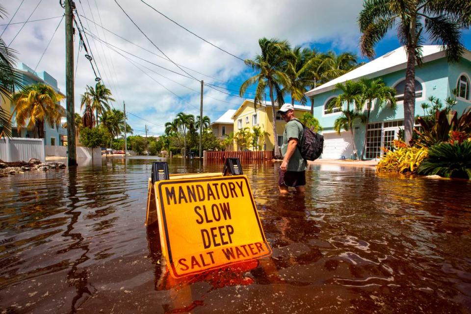 El vecino CJ Ferguson pasa por delante de un letrero que dice OBLiGATORIO IR DESPACIO AGUA SALADA PROFUNDA, durante las inundaciones debidas al huracán Ian en Stillwright Point en Cayo Largo, Florida, el jueves 29 de septiembre de 2022. Daniel A. Varela dvarela@miamiherald.com
