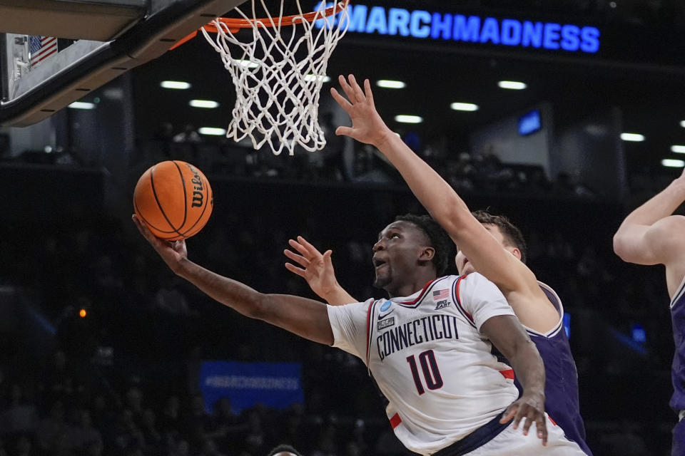 UConn's Hassan Diarra (10) drives past Northwestern's Luke Hunger during the second half of a second-round college basketball game in the NCAA Tournament Sunday, March 24, 2024, in New York. UConn won 75-58. (AP Photo/Frank Franklin II)