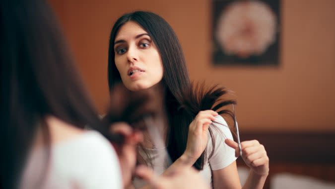 Girl changing looks giving herself a with DIY cut.