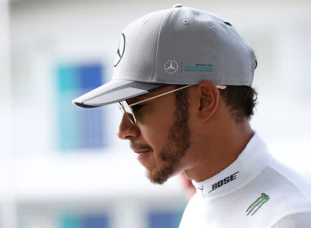 Mercedes' Lewis Hamilton of Britain walks in the paddock area before first practice. REUTERS/Toru Hanai