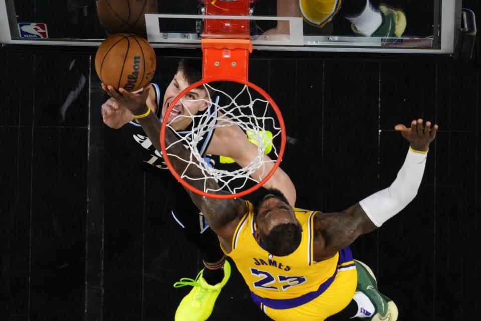 Lakers forward LeBron James blocks a reverse layup by Hawks guard Bogdan Bogdanovic.