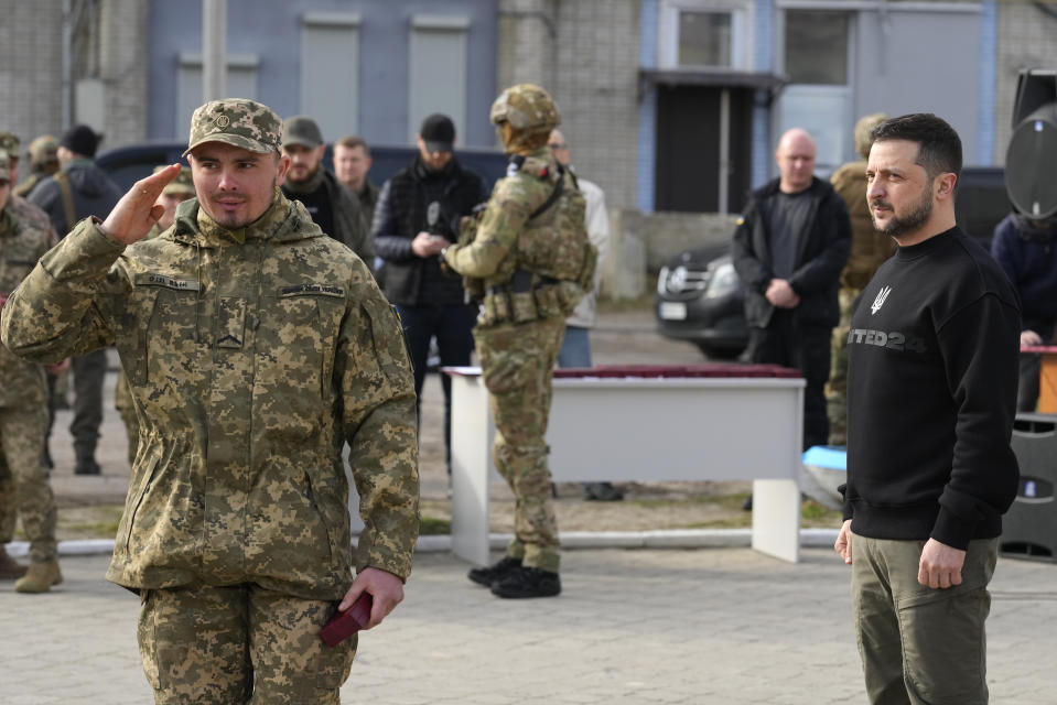 A serviceman salutes after Ukrainian President Volodymyr Zelenskyy awarded him a medal in Okhtyrka in the Sumy region of Ukraine, Tuesday March 28, 2023. (AP Photo/Efrem Lukatsky)