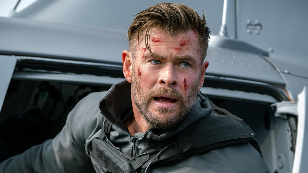  Chris Hemsworth, bruised, leans out of a helicopter in Extraction 2 