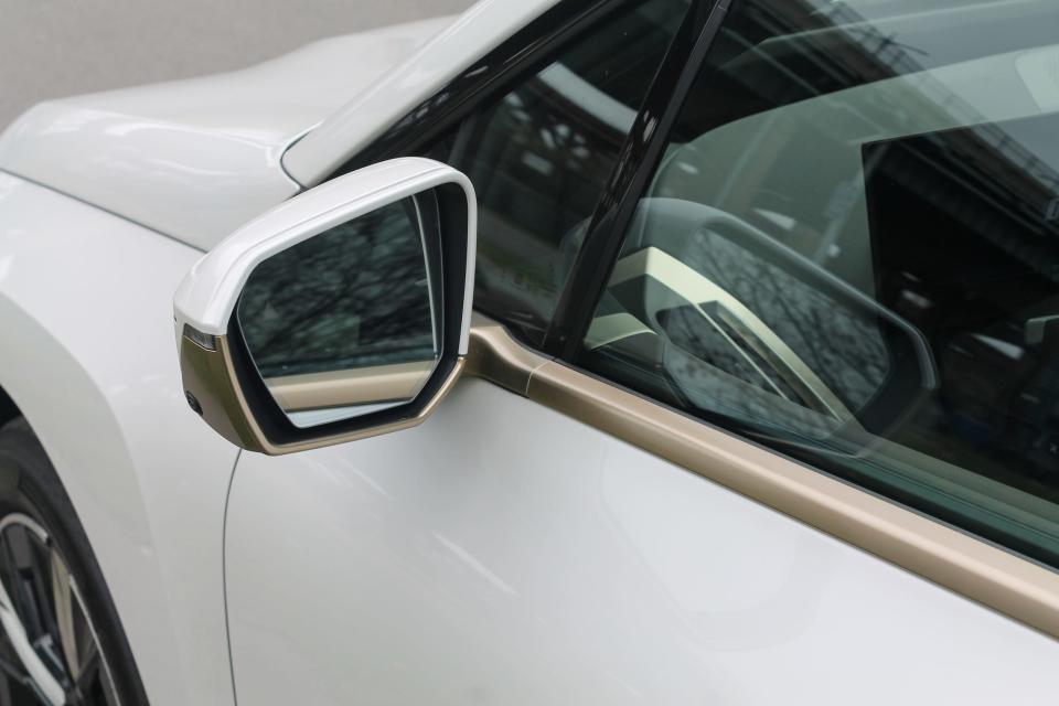 The 2022 BMW iX xDrive50's side mirror with gold trim under its window.