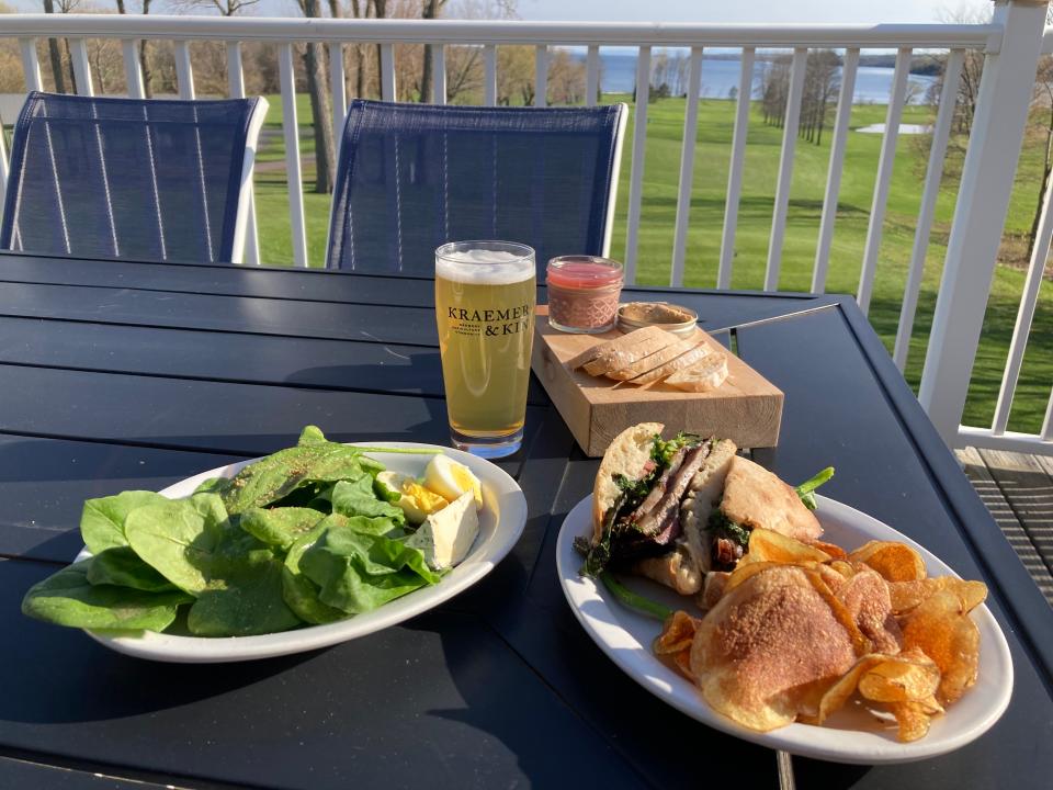 A spinach salad, liver mousse, a smoked short-rib sandwich and a blonde ale on display May 5, 2022 at the Kraemer & Kin taproom at Alburg Golf Links.