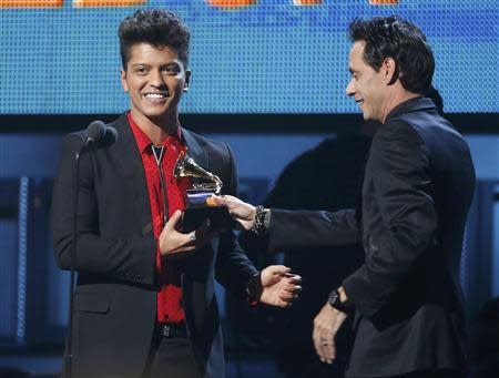 Presenter Marc Anthony (R) hands a Grammy award to Bruno Mars after he won for Best Pop Vocal Album for "Unorthodox Jukebox" at the 56th annual Grammy Awards in Los Angeles, California January 26, 2014. REUTERS/Mario Anzuoni