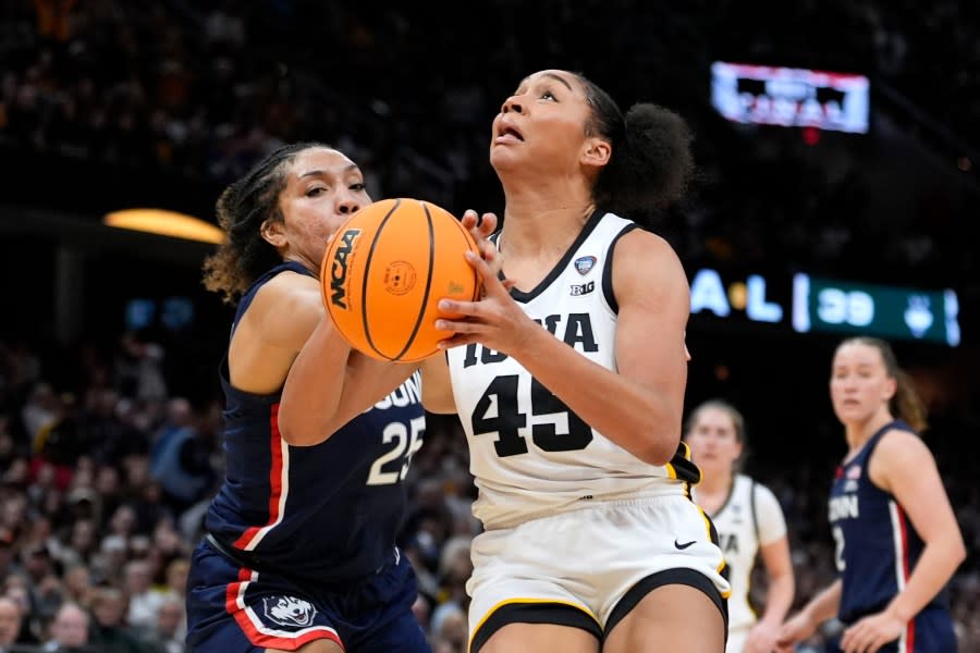 Iowa forward Hannah Stuelke (45) drives to the basket past UConn forward Ice Brady (25) during the second half of a Final Four college basketball game in the women’s NCAA Tournament, Friday, April 5, 2024, in Cleveland. (AP Photo/Morry Gash)